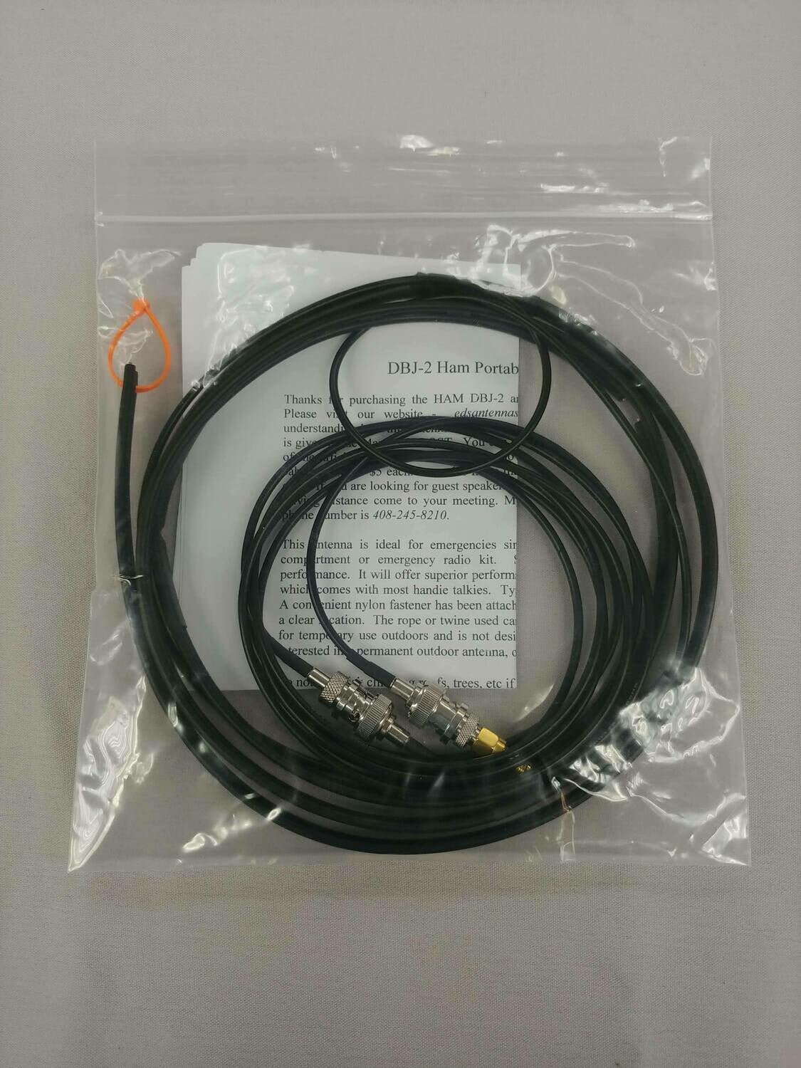 Ed Fong DBJ-2 ham antenna kit in its clear packaging, with coiled antenna, cable, adapters and instruction sheet.